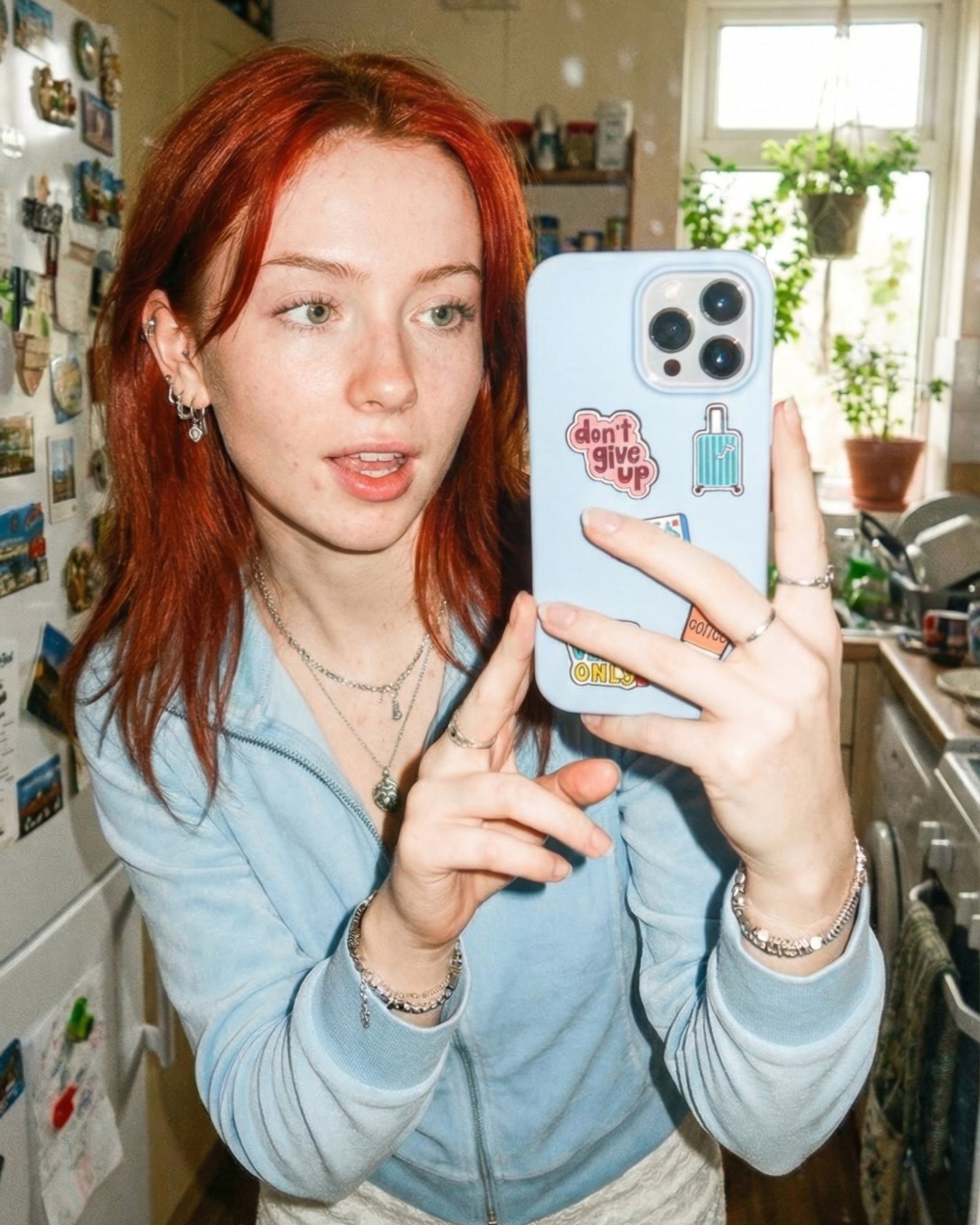 Person holding a phone with stickers in a kitchen